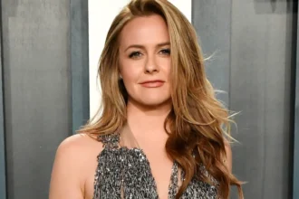 Alicia Silverstone smiling in a professional photoshoot, representing her journey from struggles to success in Bollywood and Hollywood news on AajKyaHai.com