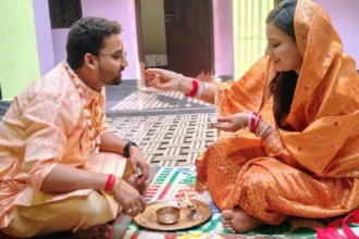 Bhai Dooj 2025 celebration with brother and sister performing tilak ceremony, traditional diya, sweets, and gifts in a festive Indian home setting