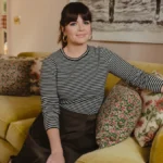 Casey Wilson smiling in a Hollywood photoshoot, celebrating her birthday and career achievements, with text overlay in Hindi and English