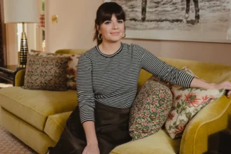 Casey Wilson smiling in a Hollywood photoshoot, celebrating her birthday and career achievements, with text overlay in Hindi and English