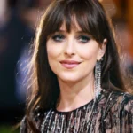 Dakota Johnson smiling in a red carpet event, with text overlay in Hindi and English about her journey from 'Fifty Shades' to Hollywood success