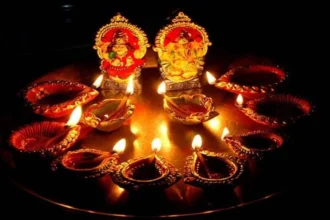 Dhanteras 2025 celebration with traditional diya, Lakshmi-Ganesh idols, and gold coins on a red cloth, symbolizing wealth and prosperity in Hindu culture.
