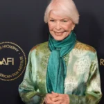 Ellen Burstyn smiling in a black and white photo, symbolizing her journey from struggle to success in Hollywood, with Hindi text overlay for AajKyaHai.com readers