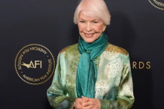 Ellen Burstyn smiling in a black and white photo, symbolizing her journey from struggle to success in Hollywood, with Hindi text overlay for AajKyaHai.com readers