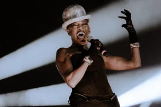 Grace Jones posing in a bold, androgynous outfit, with a mysterious expression, symbolizing her enigmatic life story - ग्रेस जोन्स की रहस्यमय जीवन कहानी की तस्वीर