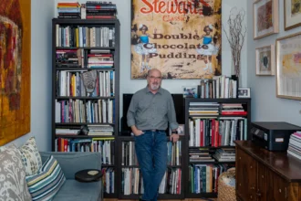 Jerry Siegel, Superman creator, black and white portrait with comic book background, biography details in Hindi and English