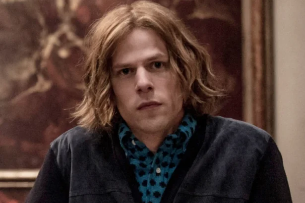 Jesse Eisenberg Hollywood actor smiling in a photoshoot, representing his inspiring journey from indie films to blockbuster hits like The Social Network, with Hindi text overlay for AajKyaHai.com audience