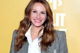 Julia Roberts smiling in a red carpet photo, with Hindi text overlay 'जूलिया रॉबर्ट्स की प्रेरणादायक जीवन कहानी' and English text 'Julia Roberts Inspirational Life Story'
