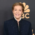 Julie Andrews smiling in a classic pose, with text overlay in Hindi and English highlighting her inspiring life journey from 'Mary Poppins' to iconic roles, set against a vibrant background for AajKyaHai.com readers.