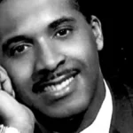 Levi Stubbs, the legendary lead singer of The Four Tops, performing on stage in a classic Motown era photo, with a vibrant background showcasing his powerful voice and soulful music.