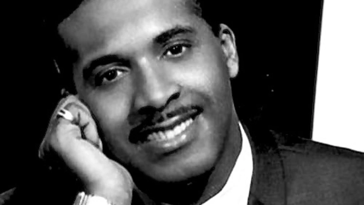 Levi Stubbs, the legendary lead singer of The Four Tops, performing on stage in a classic Motown era photo, with a vibrant background showcasing his powerful voice and soulful music.