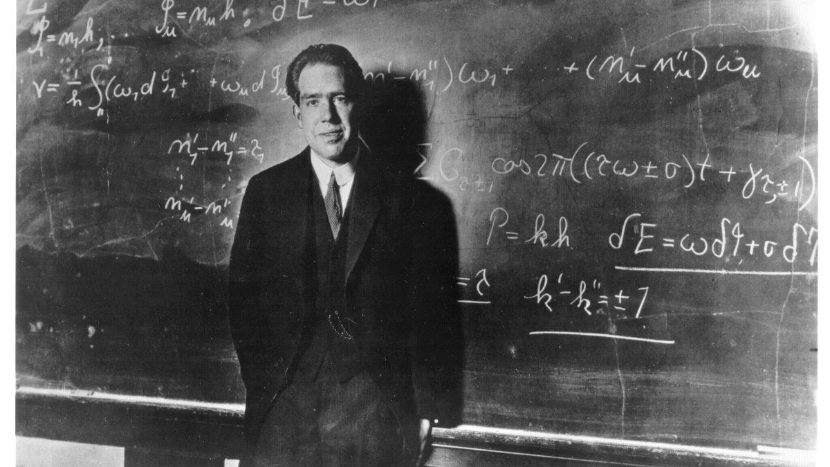 Niels Bohr atomic theory portrait with Hindi and English text overlay, showing his contributions to quantum physics on AajKyaHai.com