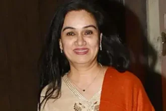 Padmini Kolhapure smiling portrait in traditional Indian attire, with Hindi text 'पद्मिनी कोल्हापुरे जीवनी' and English text 'Padmini Kolhapure Biography' overlaid, representing her Bollywood career and personal life story on AajKyaHai.com