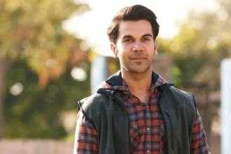 Rajkummar Rao smiling in a casual photoshoot, wearing a simple shirt, with a thoughtful expression representing his journey from Gurugram to Bollywood stardom