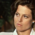 Sigourney Weaver smiling in a professional photoshoot, with text overlay in Hindi and English highlighting her journey from struggle to success, optimized for AajKyaHai.com