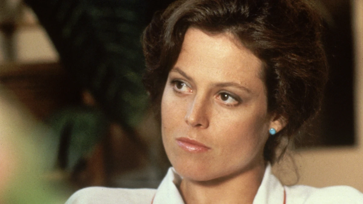 Sigourney Weaver: संघर्ष से सफलता तक 1 Sigourney Weaver smiling in a professional photoshoot, with text overlay in Hindi and English highlighting her journey from struggle to success, optimized for AajKyaHai.com