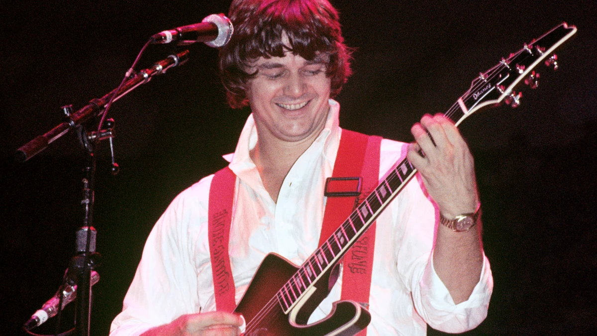 Steve Miller: संगीत यात्रा और सफलता 1 Steve Miller playing guitar on stage during a live performance, with a cheering audience in the background, showcasing his rock and blues music career.