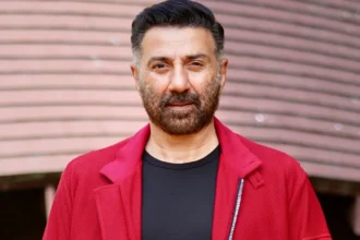 Sunny Deol smiling in a Bollywood poster with Indian flag colors, celebrating his birthday with film scenes from Gadar and Border in background